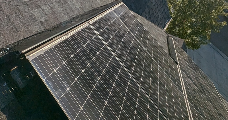A bunch of solar panels are sitting on top of a roof.