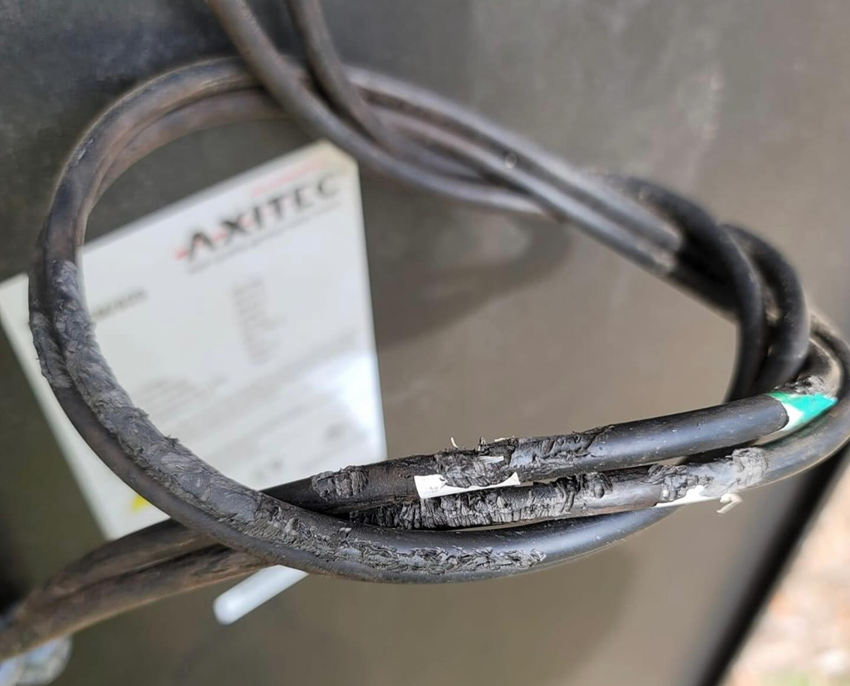 A close up of a black wire with a label on it.