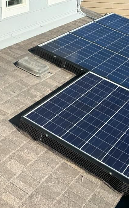 A row of solar panels are sitting on top of a roof.