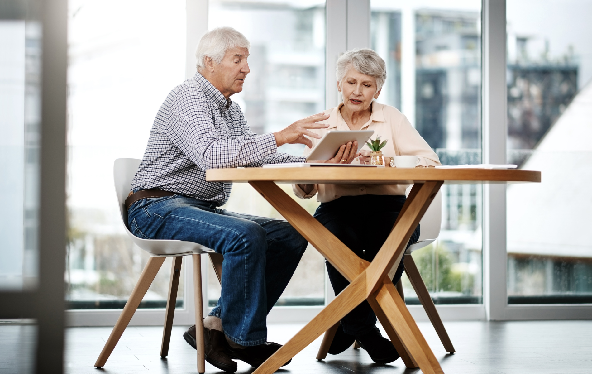 Two people talking at a wooden table in a bright modern room