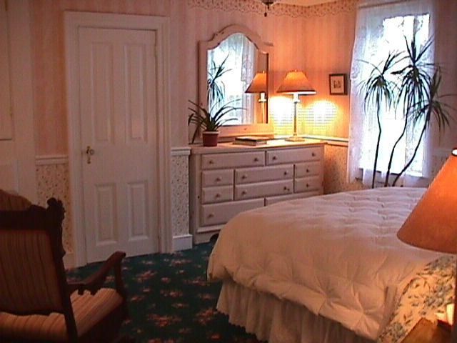 A bedroom with a large bed and a dresser
