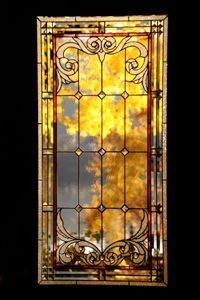 A stained glass window with a picture of a fire coming out of it.