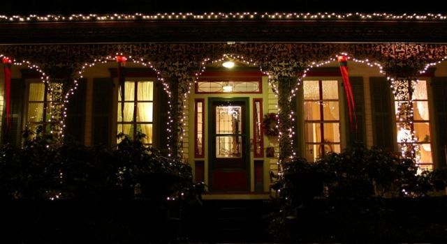 The front of a house decorated with christmas lights at night.