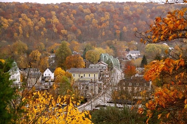 An aerial view of a small town surrounded by trees in autumn