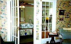 A living room with french doors leading to a bedroom.