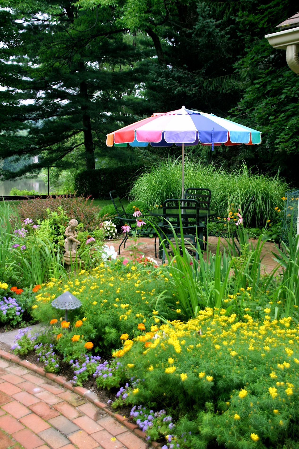 A colorful umbrella sits in the middle of a garden