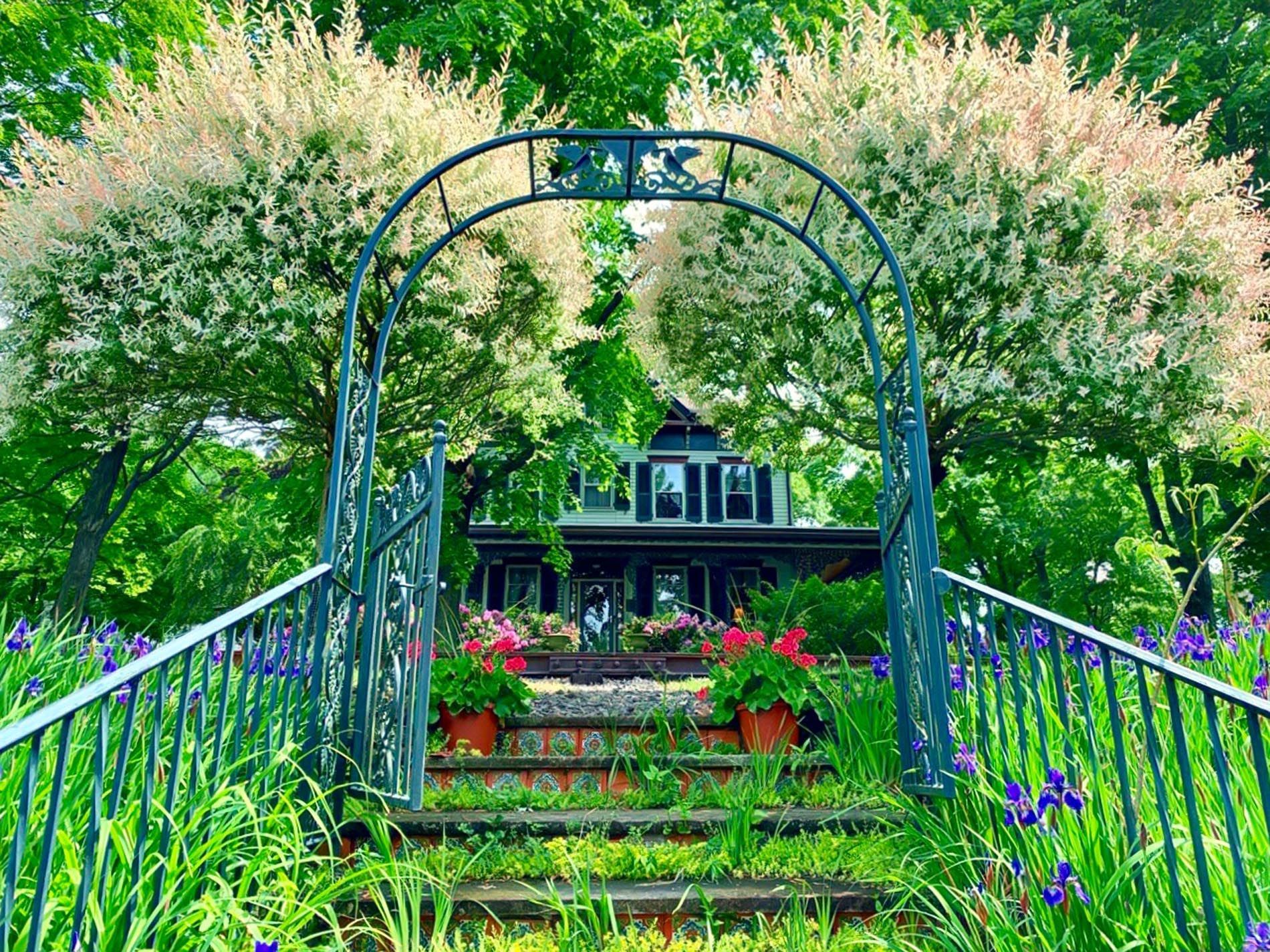 A garden with a house in the background and steps leading to it.