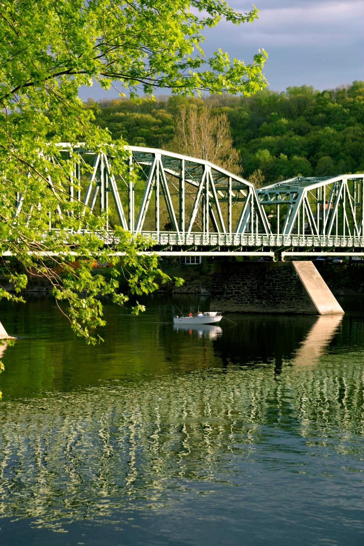 A bridge over a river with a boat in the water