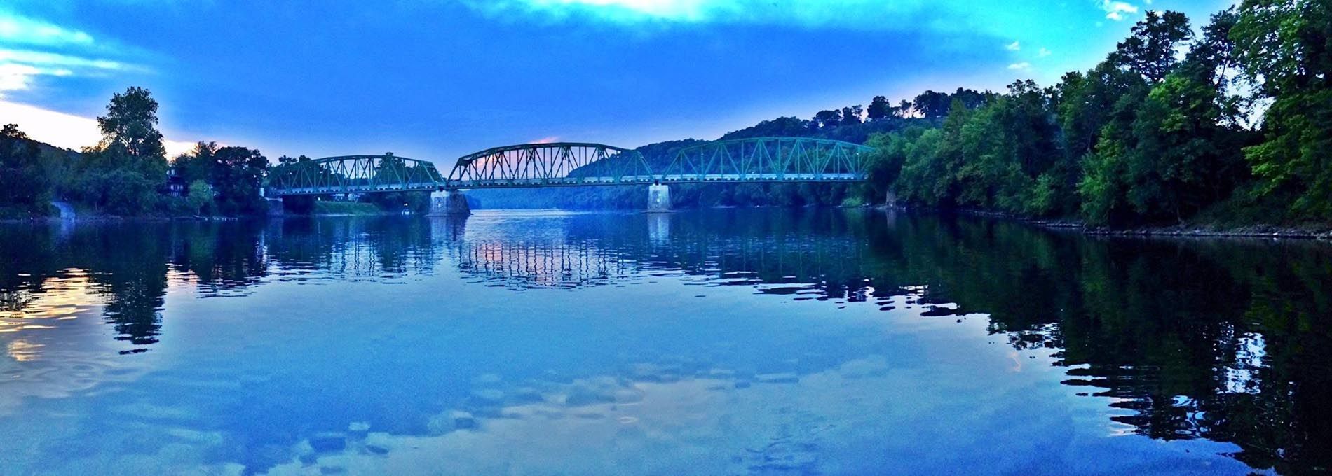 A bridge over a body of water with trees in the background