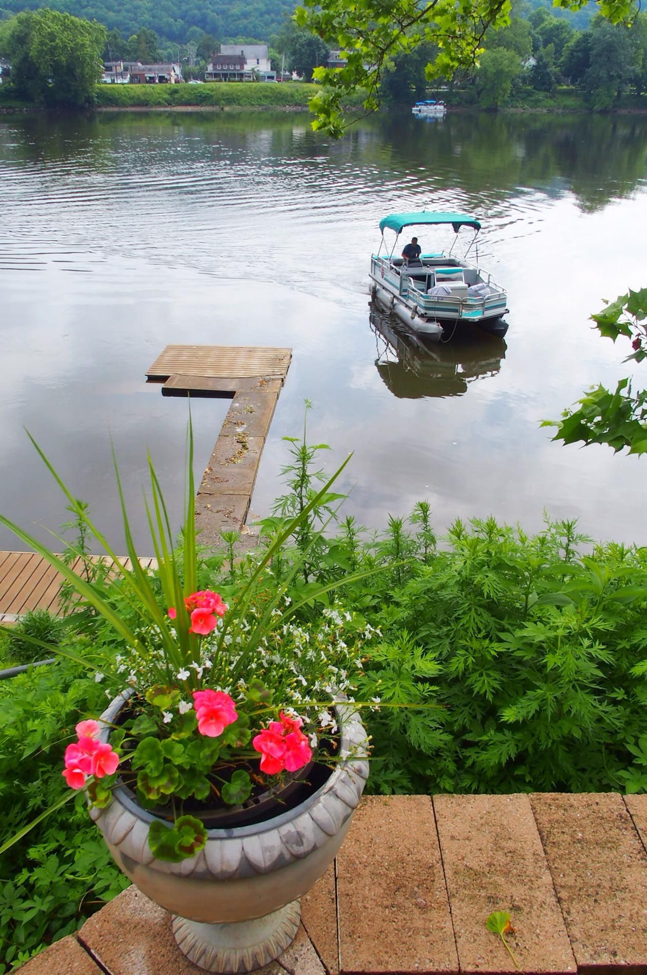 A boat is floating on a lake next to a flower pot