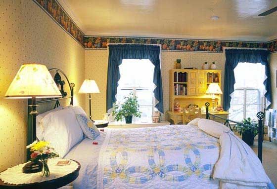 A bedroom with a large bed and two lamps