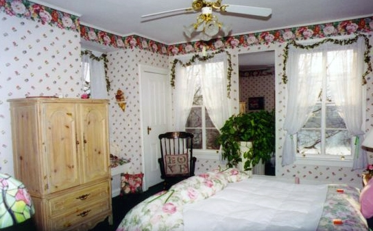 A bedroom with a bed and a ceiling fan