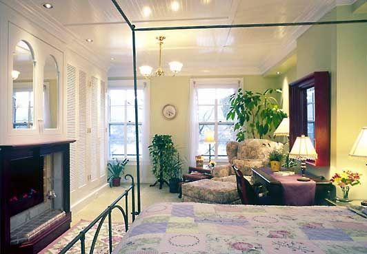 A bedroom with a canopy bed and a fireplace