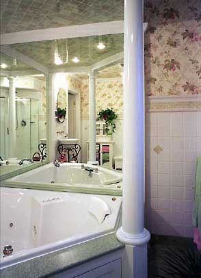 A bathroom with a jacuzzi tub and a mirror.