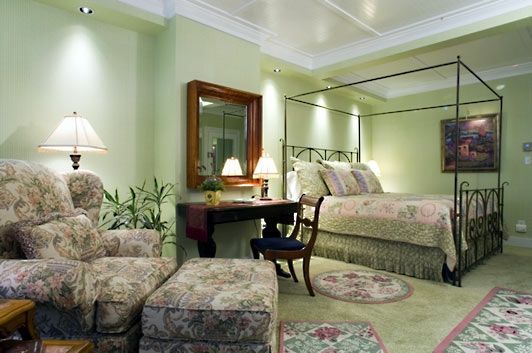 A bedroom with a canopy bed and a chair