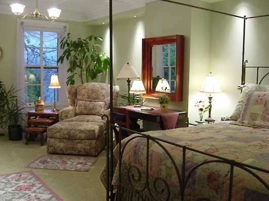 A bedroom with a four poster bed and a chair
