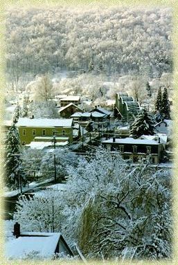 A snowy village with houses and trees covered in snow