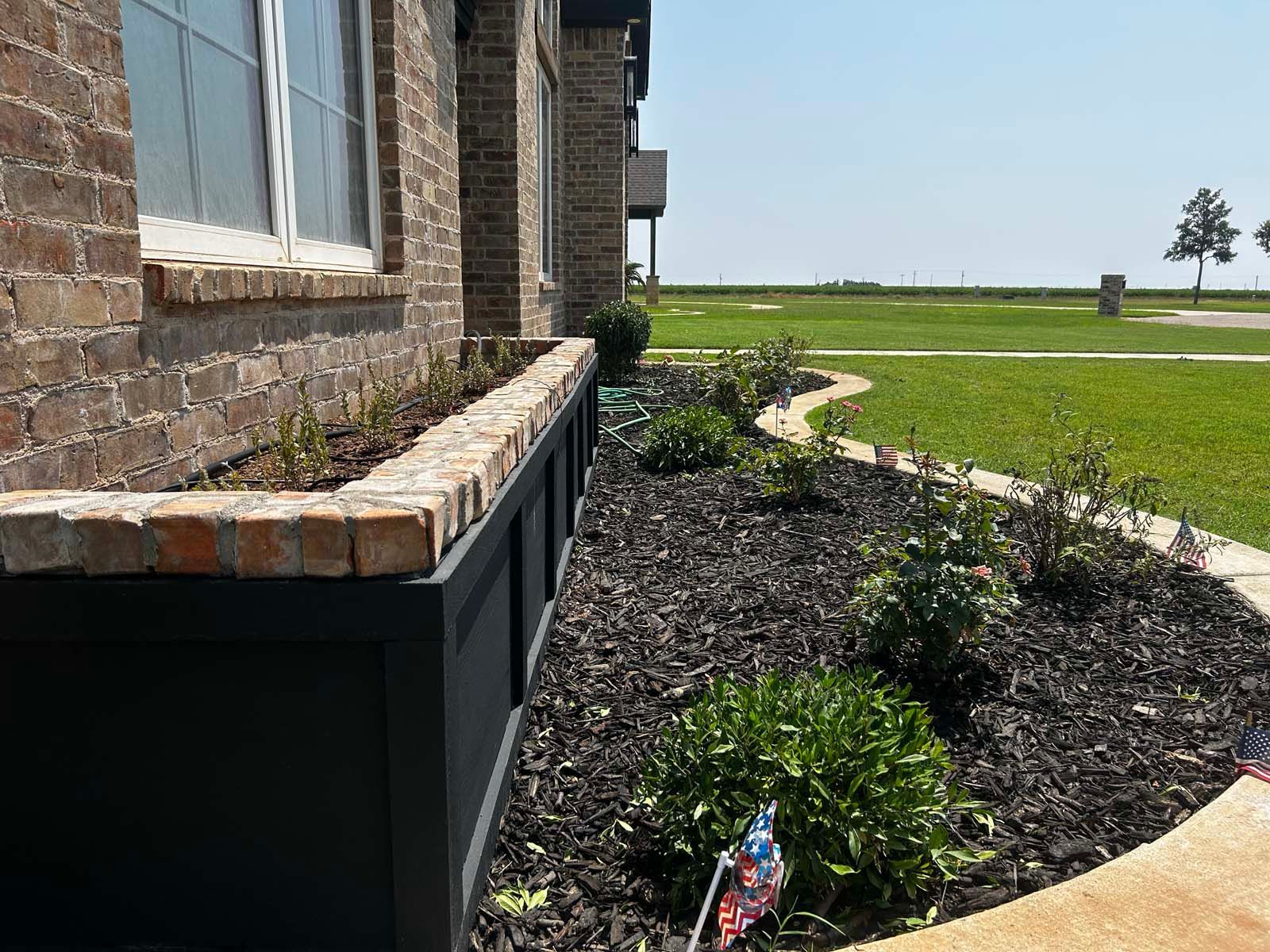 A brick house with a garden in front of it.