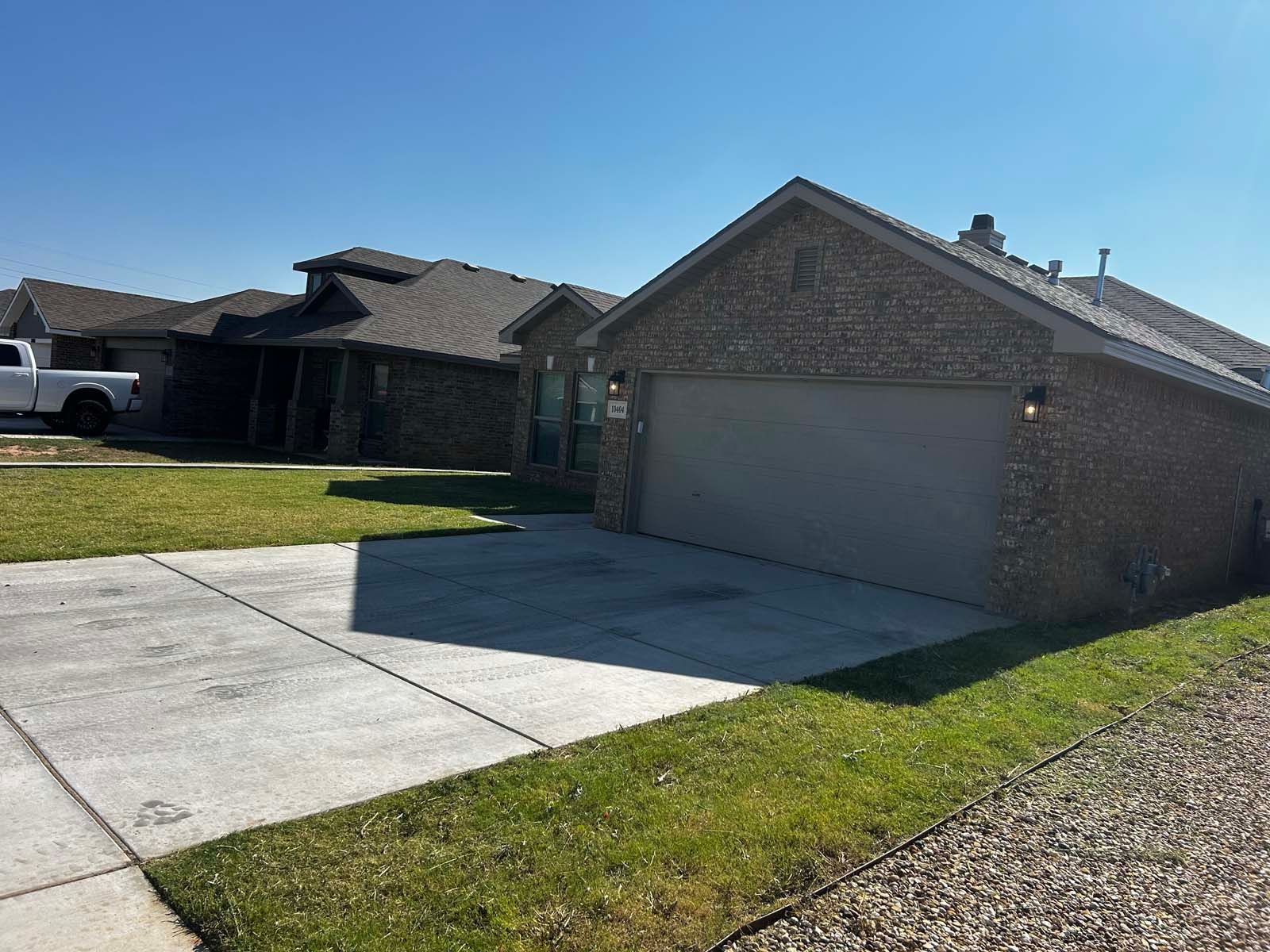 A white truck is parked in front of a house with a garage