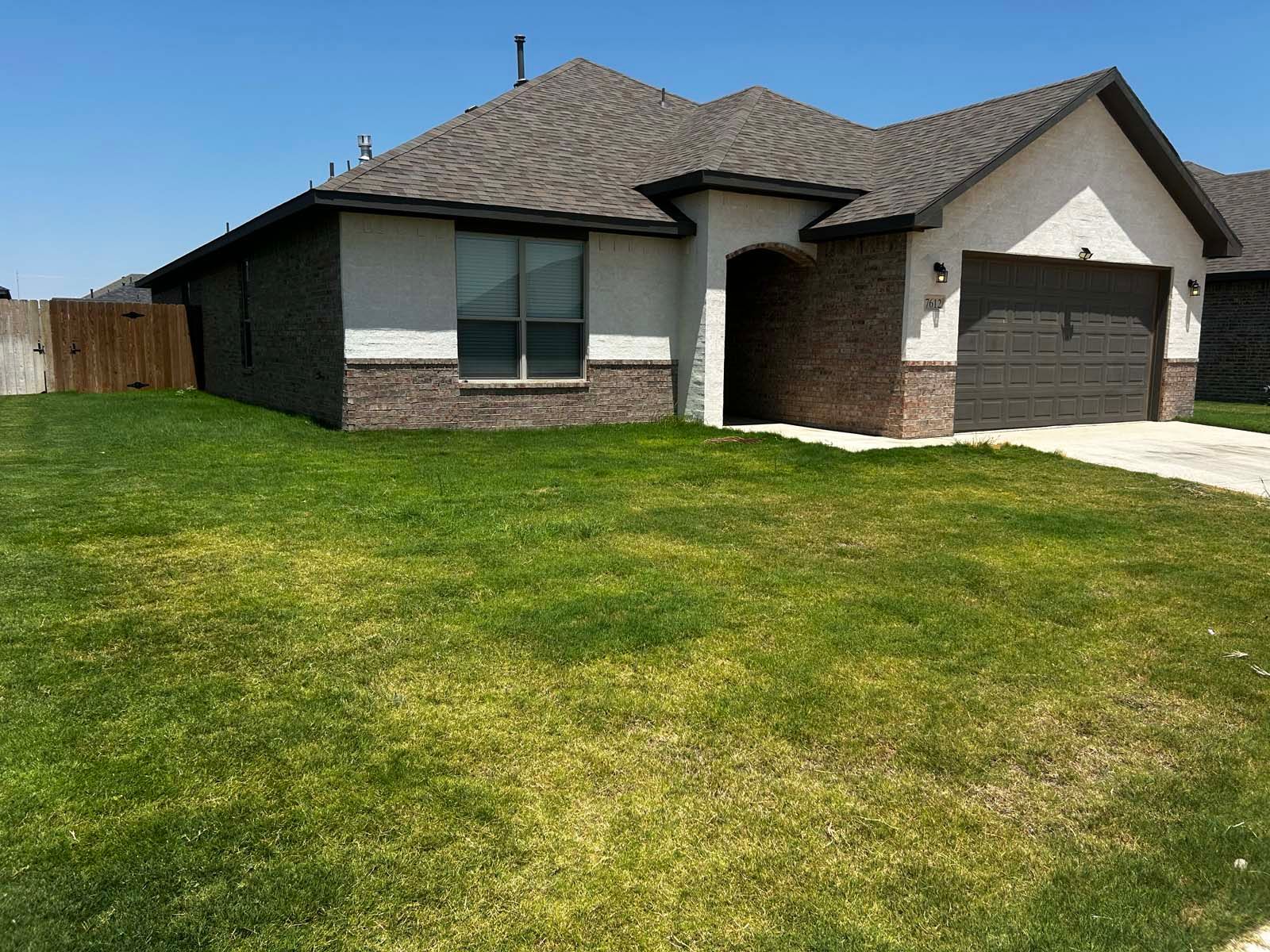 A house with a large lawn in front of it