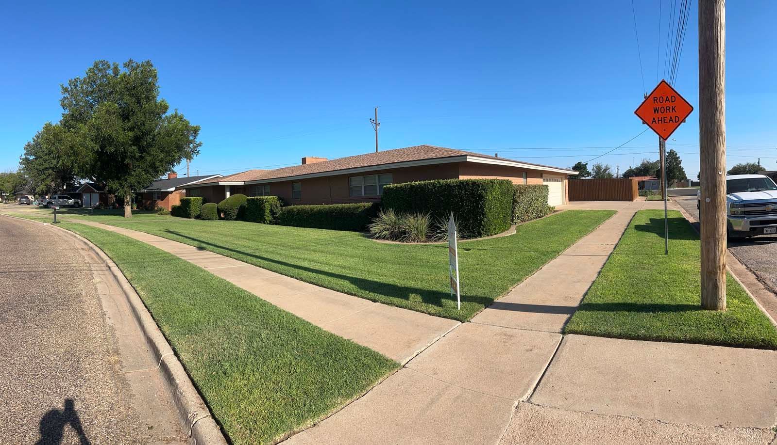 A stop sign is on the side of the road in front of a house.