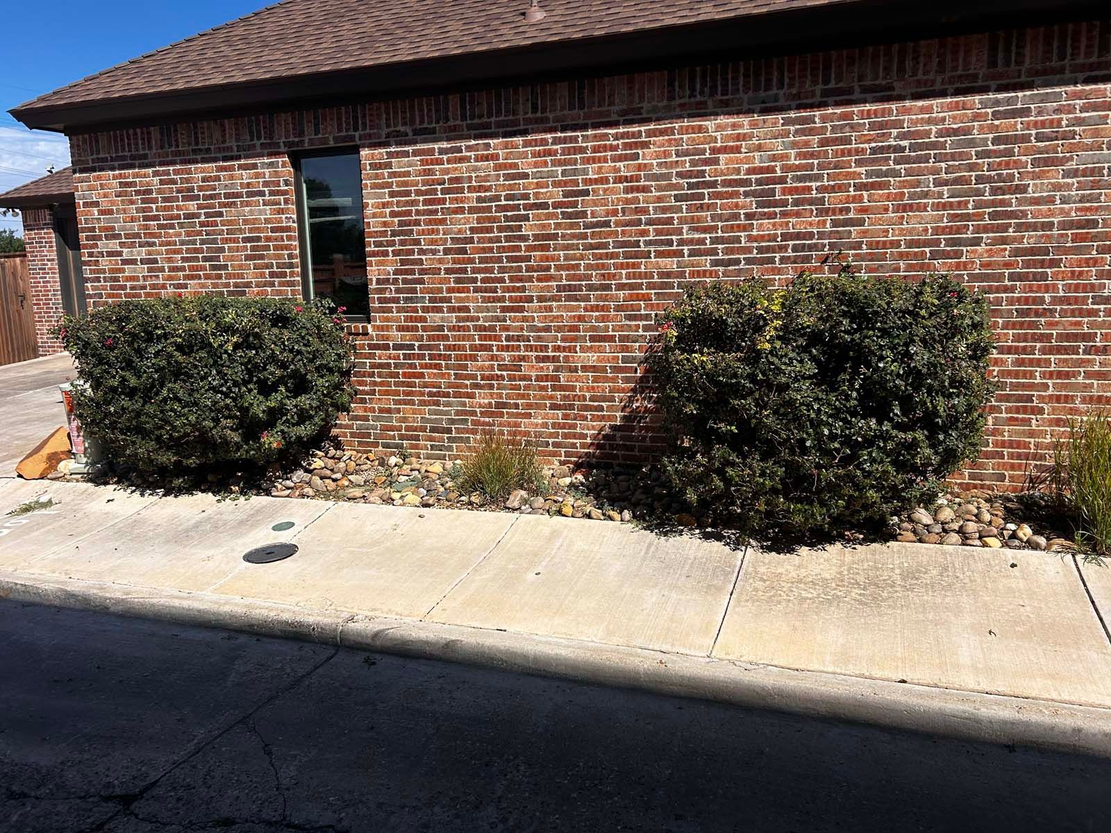 A brick building with bushes in front of it