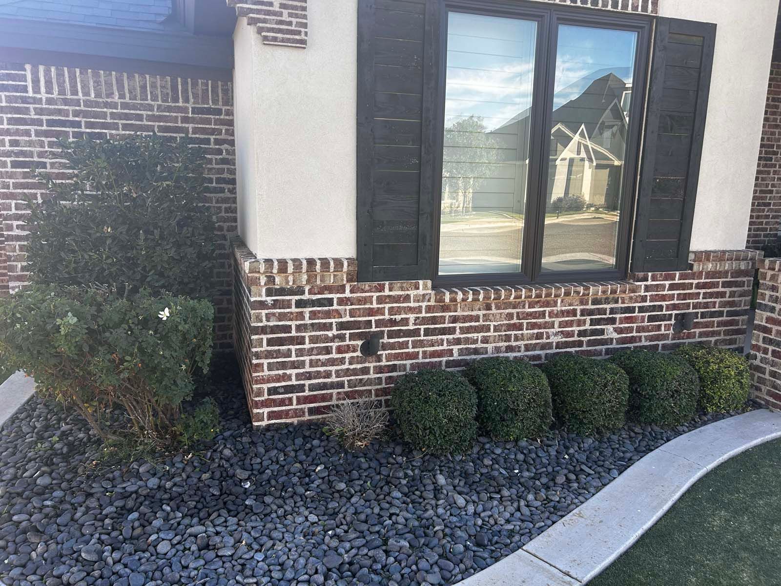 A brick building with a window and shutters on it