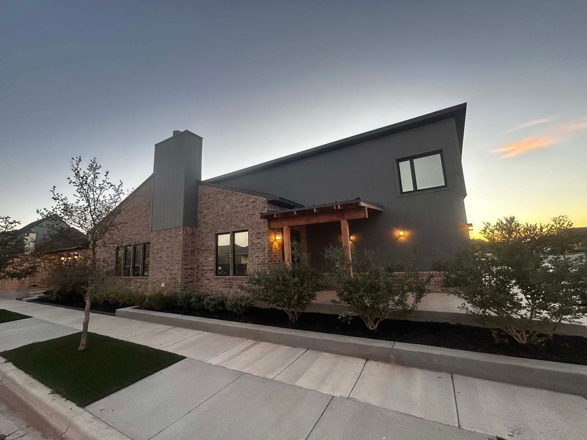 A large house with a lot of windows and a chimney on the side of it.