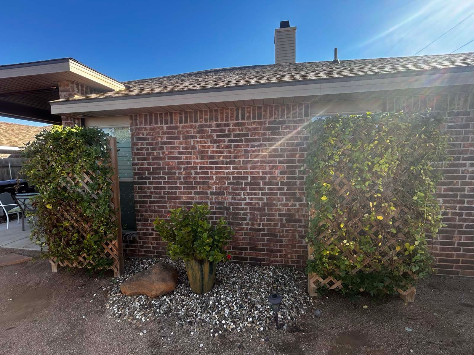 A brick house with a garden in front of it.