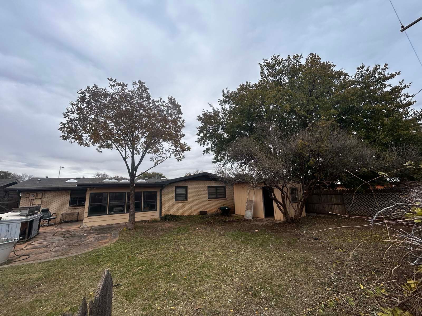A house with a lot of grass and trees in front of it.