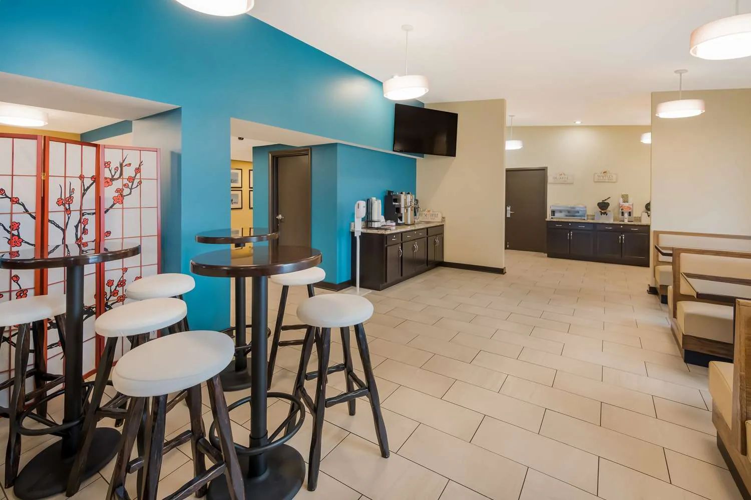 A large white and blue building with a parking lot in front of it.