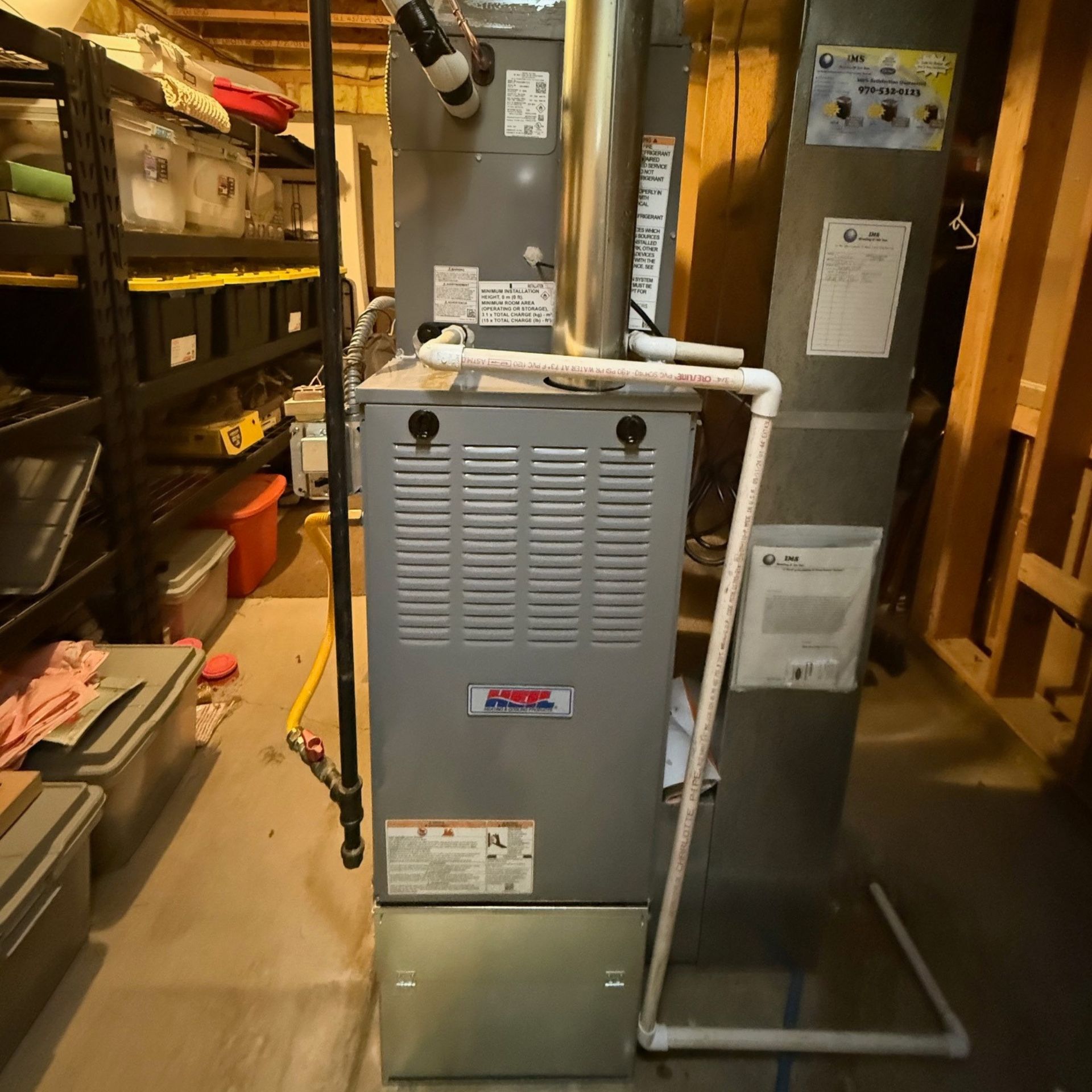 E.Squared Custom Plumbing Heating and Air - Furnace unit in a basement next to shelving.