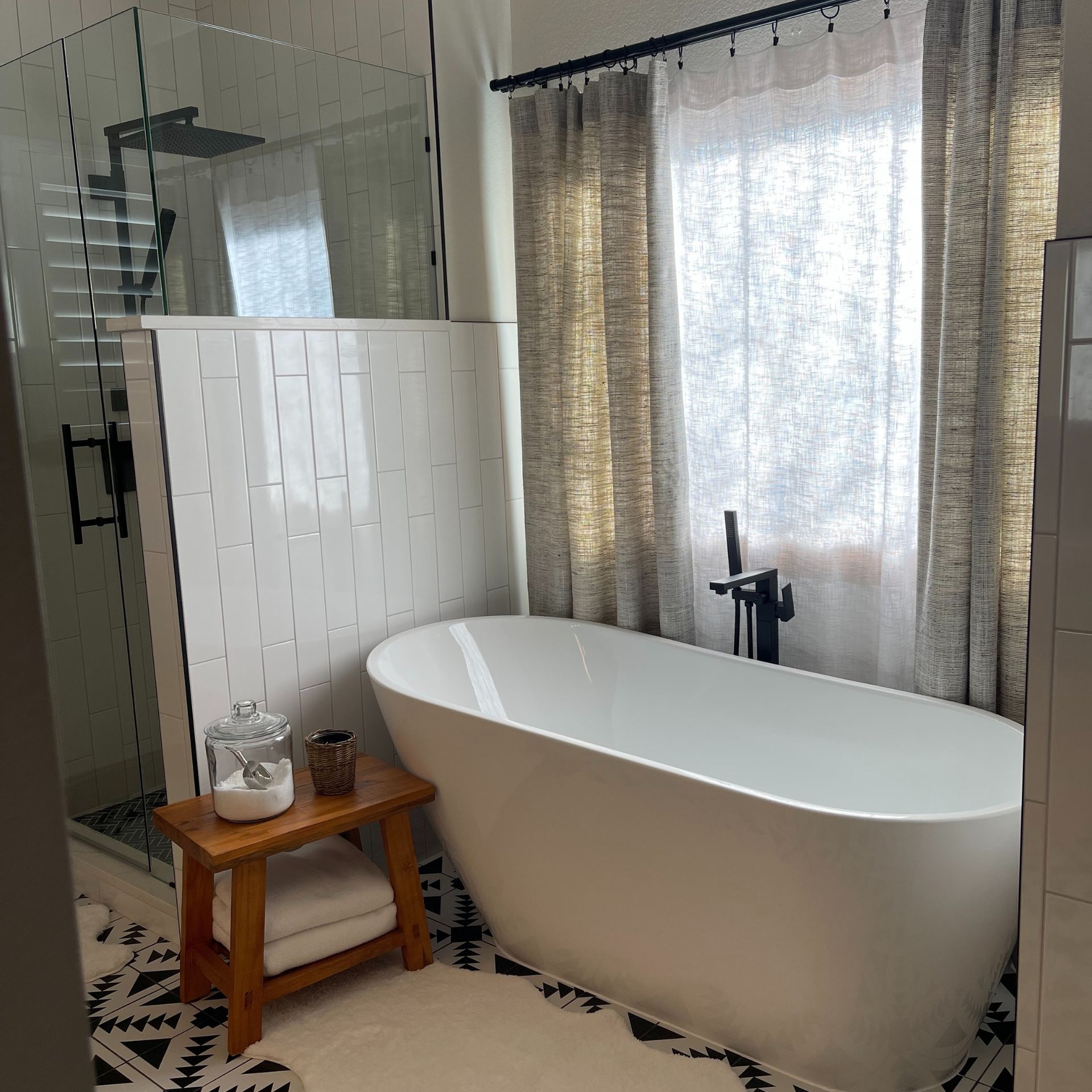 E.Squared Custom Plumbing Heating and Air - Modern bathroom with white tub, black and white rug, glass shower.