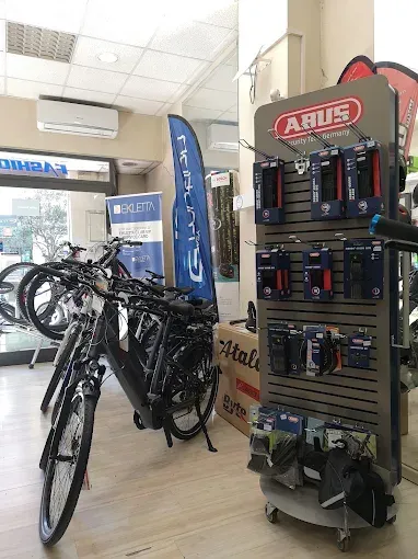 Interno di un negozio di biciclette con bici esposte, lucchetti di sicurezza e accessori.
