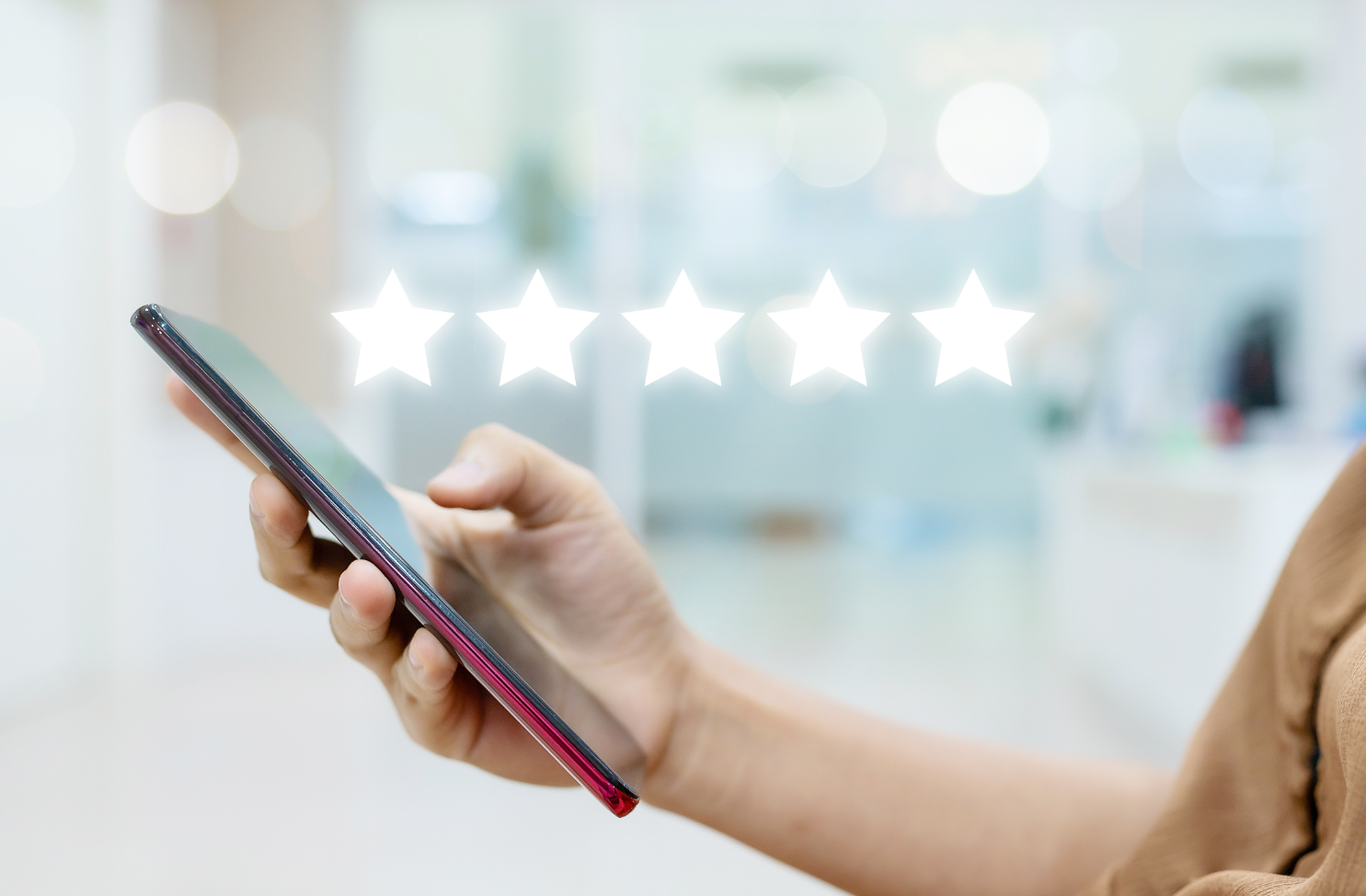 a person is holding a cell phone with five stars on it .