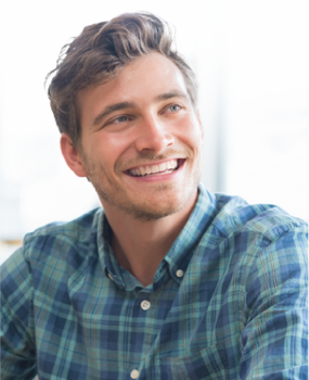 a man in a plaid shirt is smiling and looking to the side .