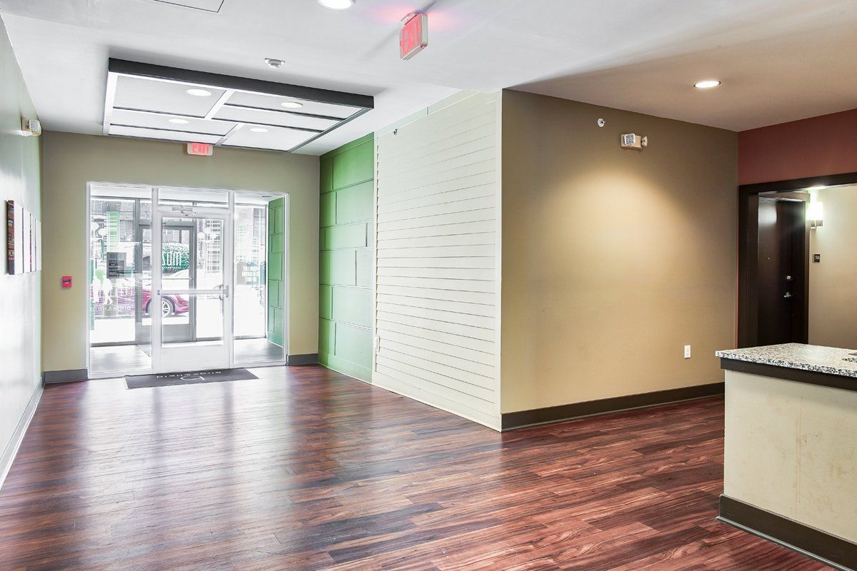 A large empty room with hardwood floors and a sliding glass door.