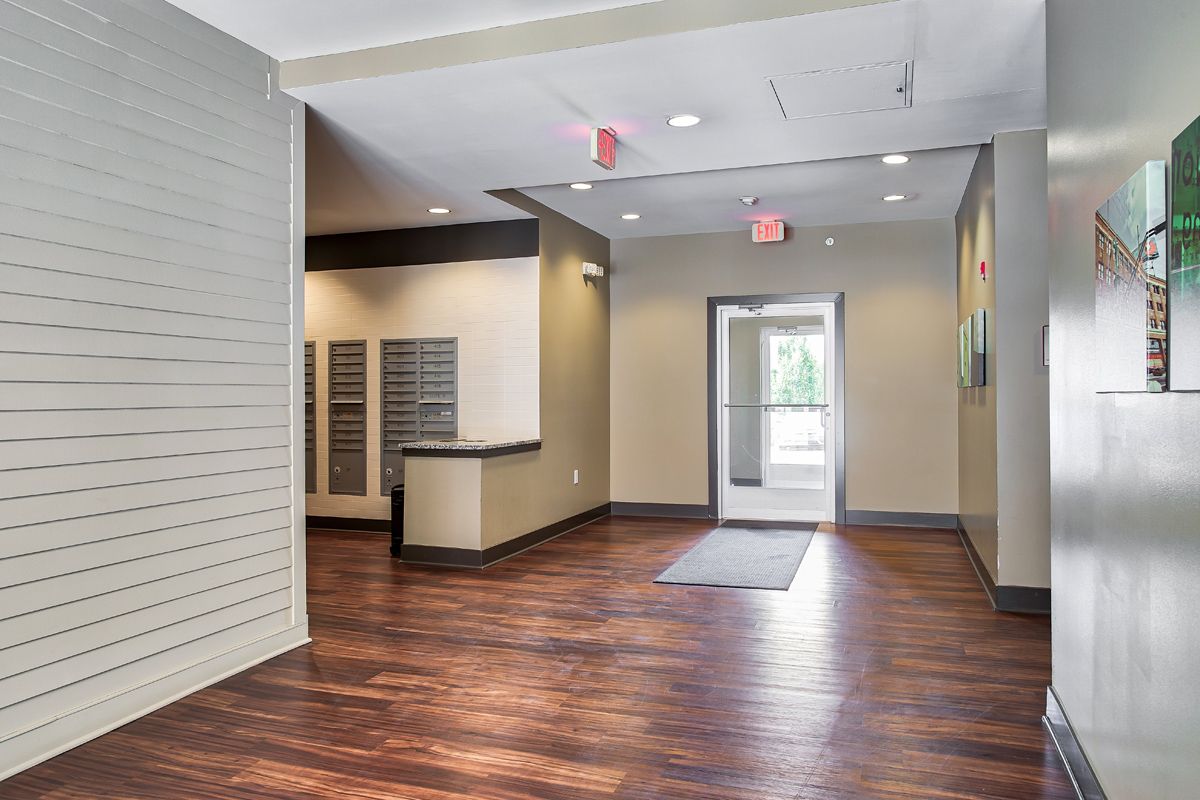 An empty lobby with a wooden floor and a door