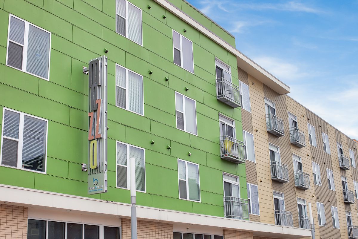 A green building with a lot of windows and balconies