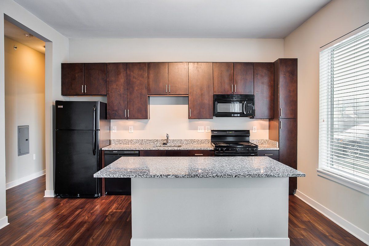 A kitchen with a large island and a black refrigerator