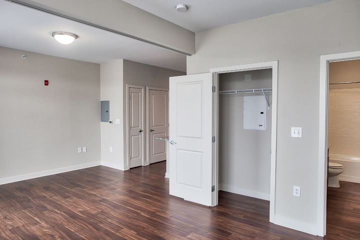 An empty apartment with hardwood floors and white walls.