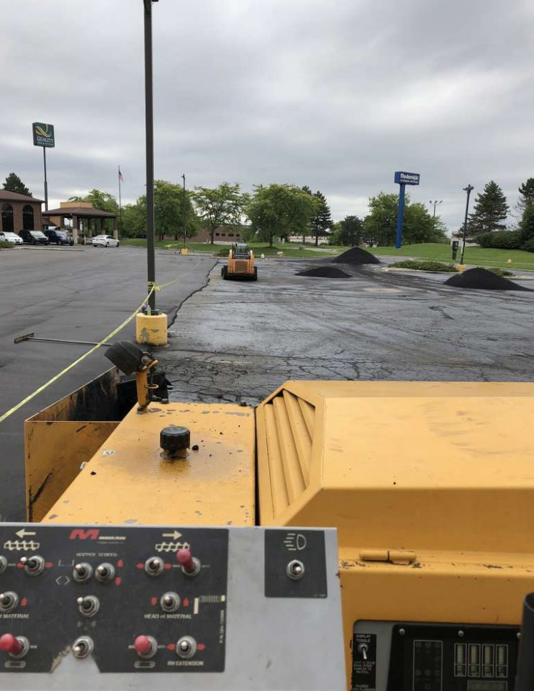 A yellow tractor is parked in a parking lot