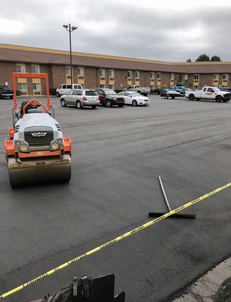 A parking lot with cars parked in front of a building