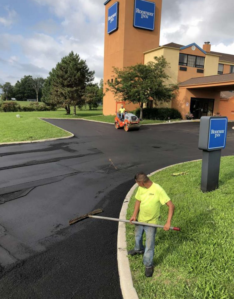 A man in a yellow shirt is holding a broom in front of a sign that says hampton inn