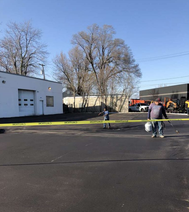 A man is walking down a street next to a yellow tape.