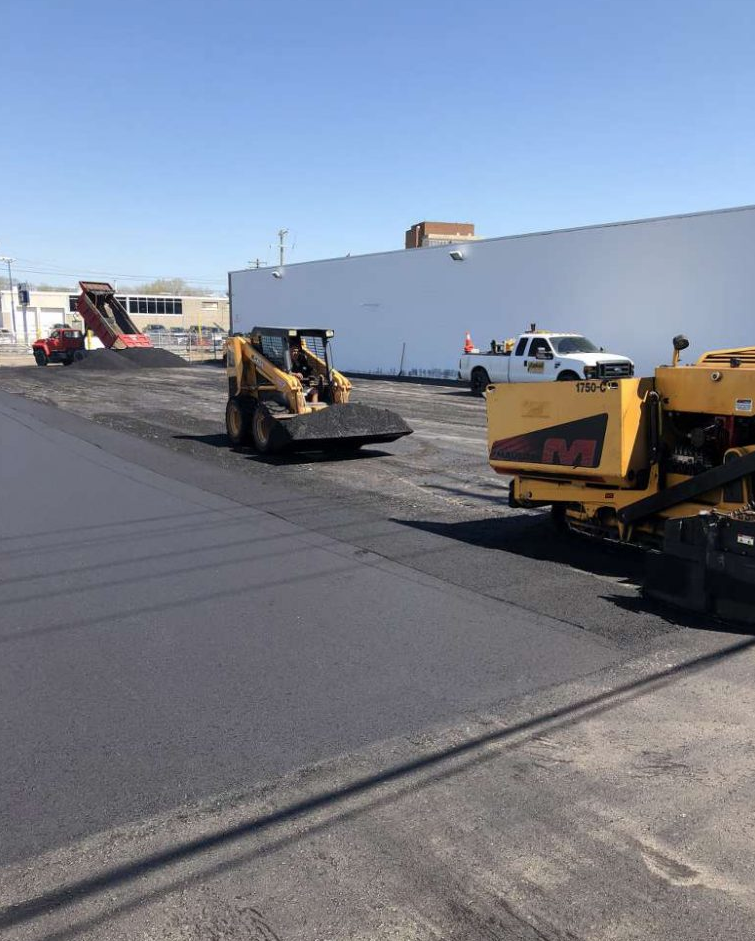 A group of construction vehicles are working on a road.