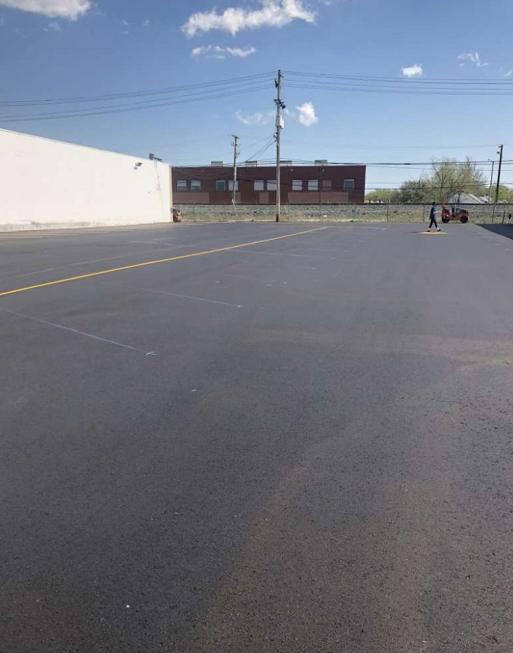 A large parking lot with a white building in the background.
