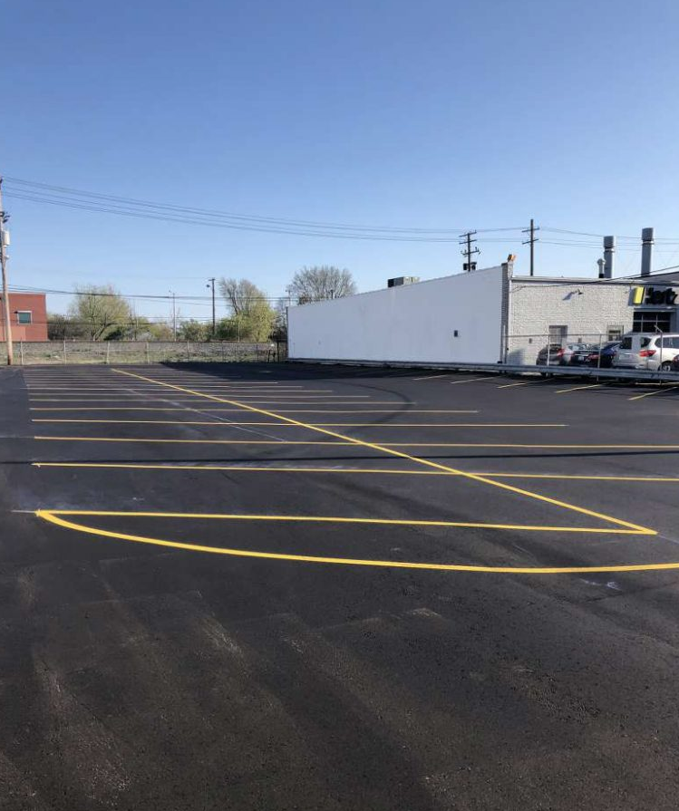 A parking lot with a white building in the background
