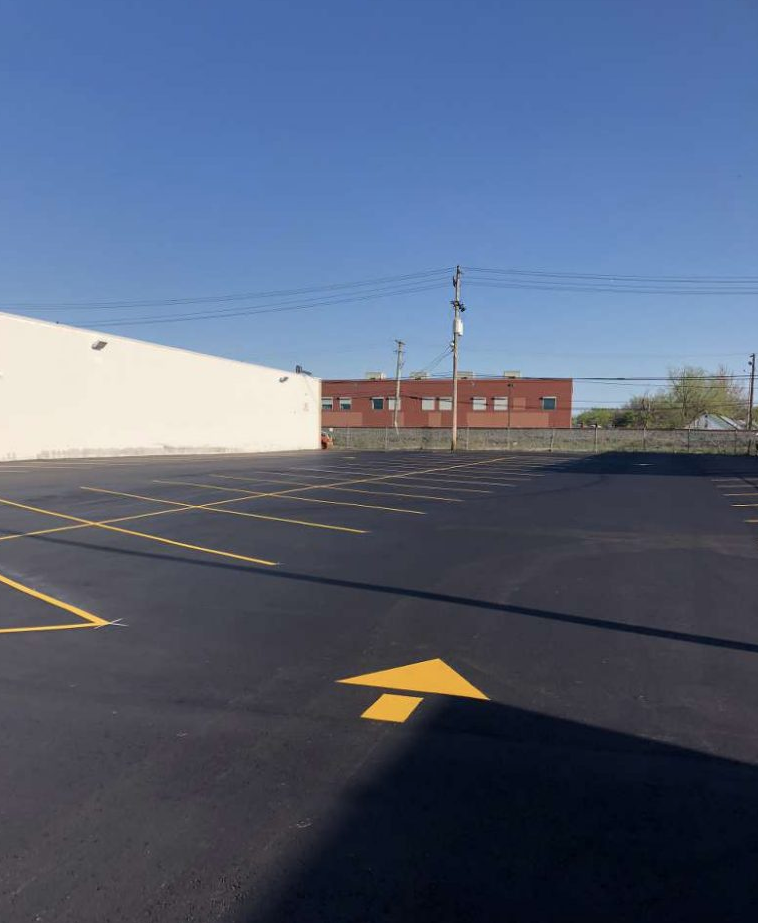 A parking lot with a yellow arrow pointing to the right.