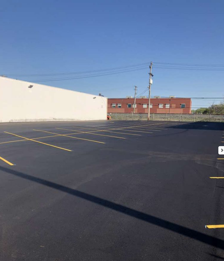 A parking lot with a white building in the background.
